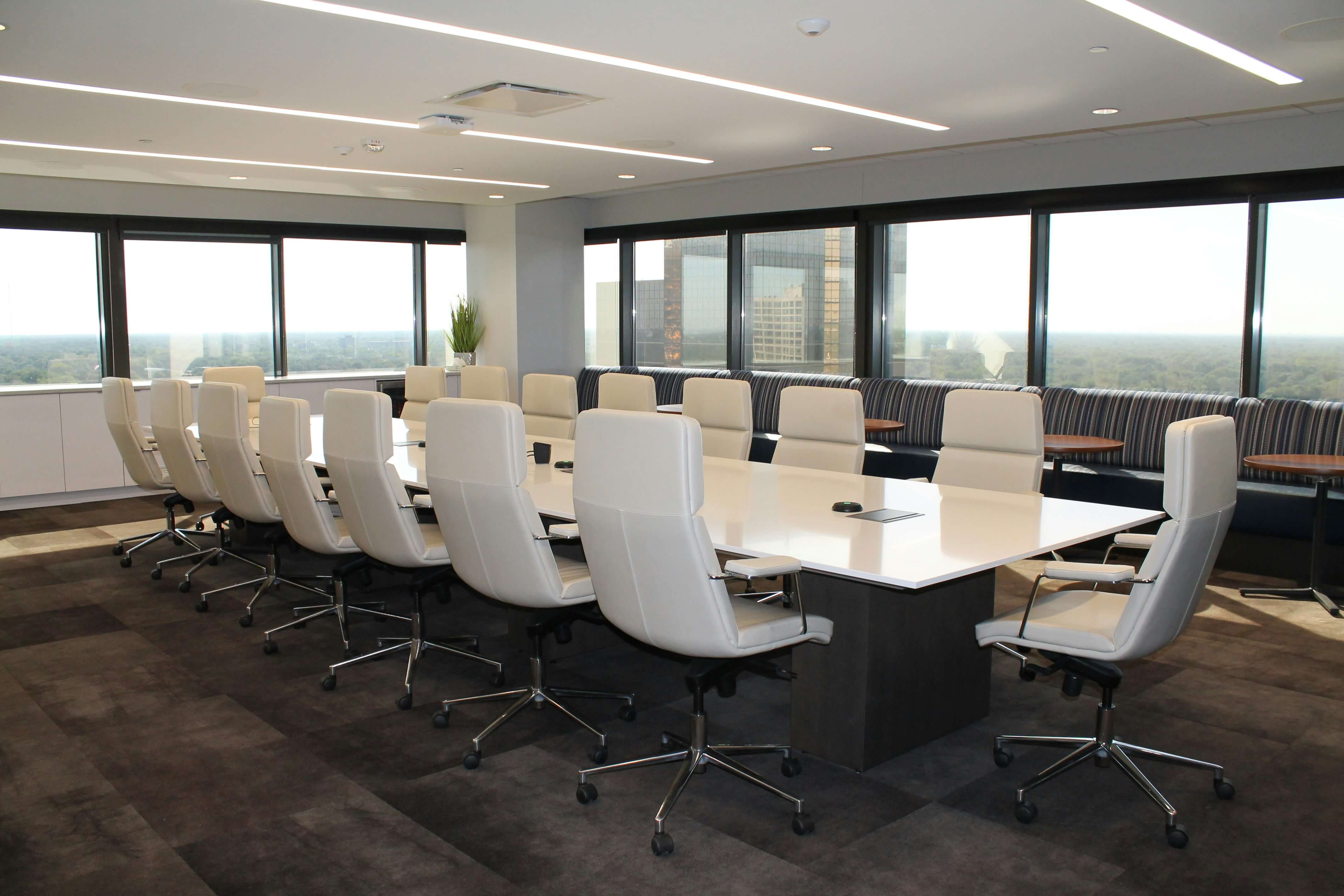 Modern boardroom desk with a city skyline visible through the window