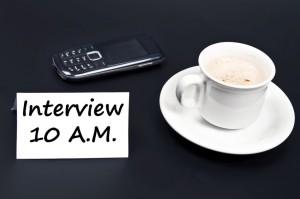 picutre of cup, mobile and paper with interview at 10am